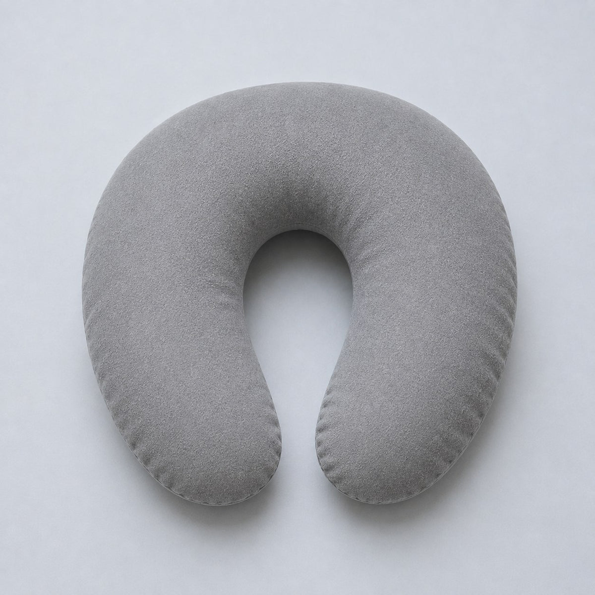 A standard U-shaped travel pillow from above, open at the front